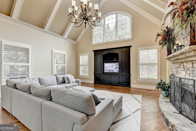 living room with built in features, high vaulted ceiling, and light wood-type flooring