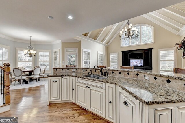 kitchen featuring dark stone countertops, appliances with stainless steel finishes, ornamental molding, and light wood-type flooring