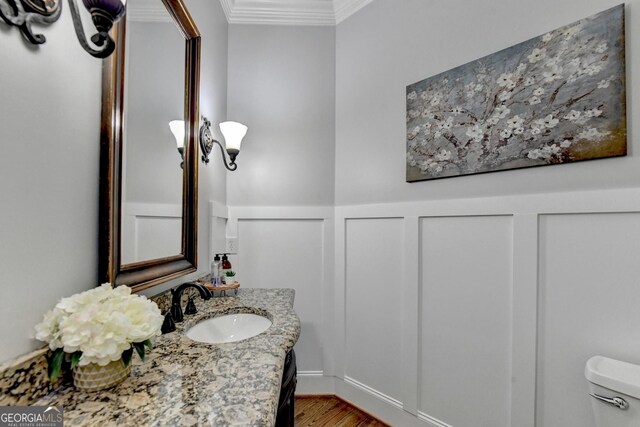 kitchen featuring light wood-type flooring, sink, built in appliances, crown molding, and a center island