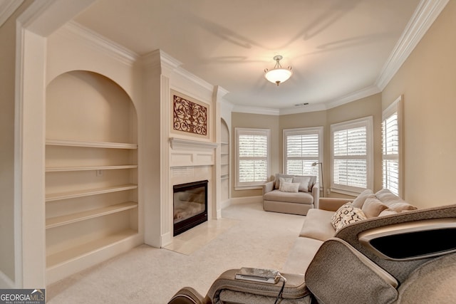 living room featuring ornamental molding, light colored carpet, a tile fireplace, and built in features