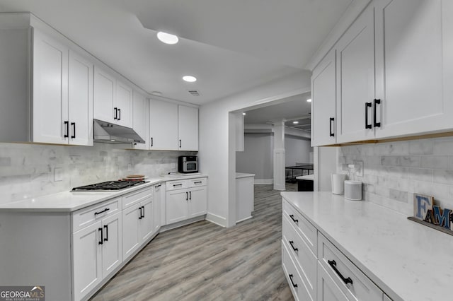 kitchen featuring white cabinetry, stainless steel gas cooktop, tasteful backsplash, and light wood-type flooring