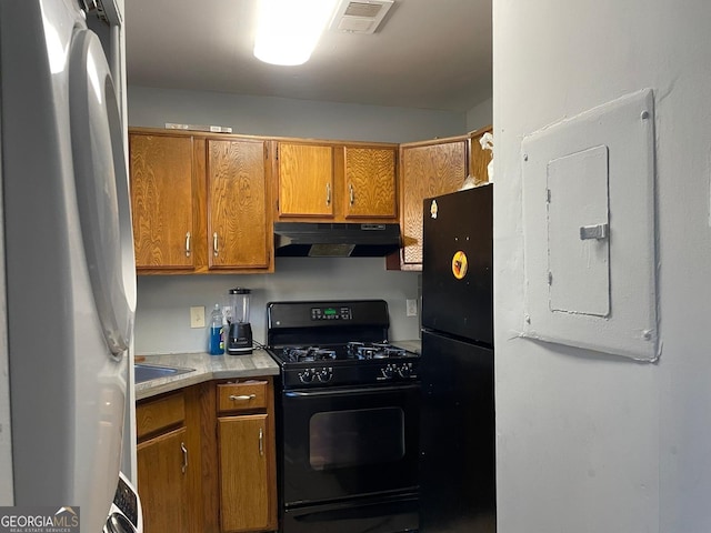 300 Flagstone Way, Austell, GA 30168 - kitchen with brown cabinetry, visible vents, electric panel, black appliances, and under cabinet range hood