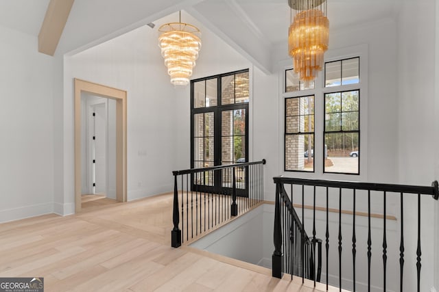 interior space with a notable chandelier, wood-type flooring, and ornamental molding