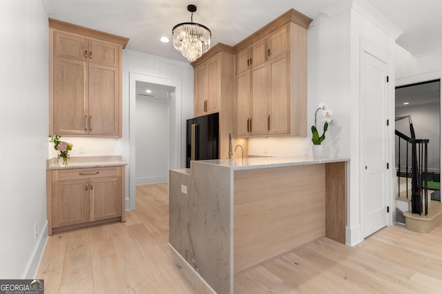 kitchen featuring pendant lighting, high end black refrigerator, light brown cabinetry, and light hardwood / wood-style floors