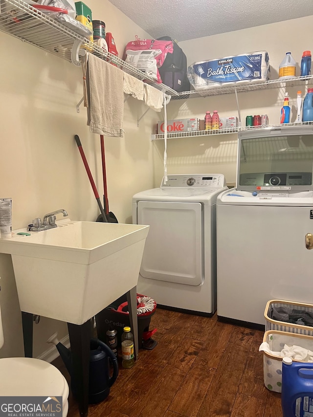 laundry room with sink, a textured ceiling, washer and dryer, and dark hardwood / wood-style floors