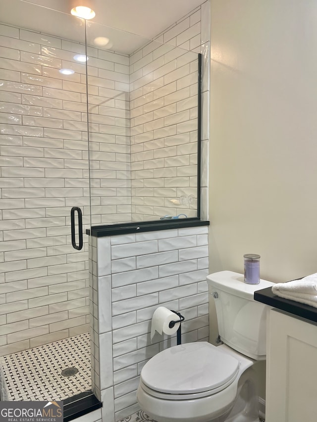 bathroom with toilet, a shower with shower door, and vanity