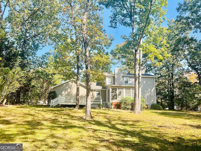 view of front of property with a front yard, a deck, and a sunroom