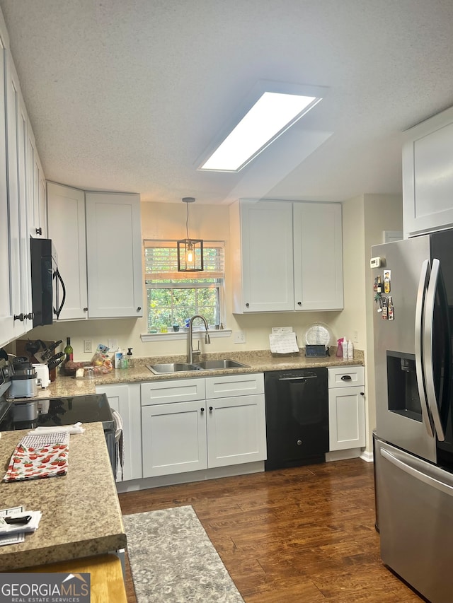 kitchen with white cabinets, hanging light fixtures, dark hardwood / wood-style floors, black appliances, and sink