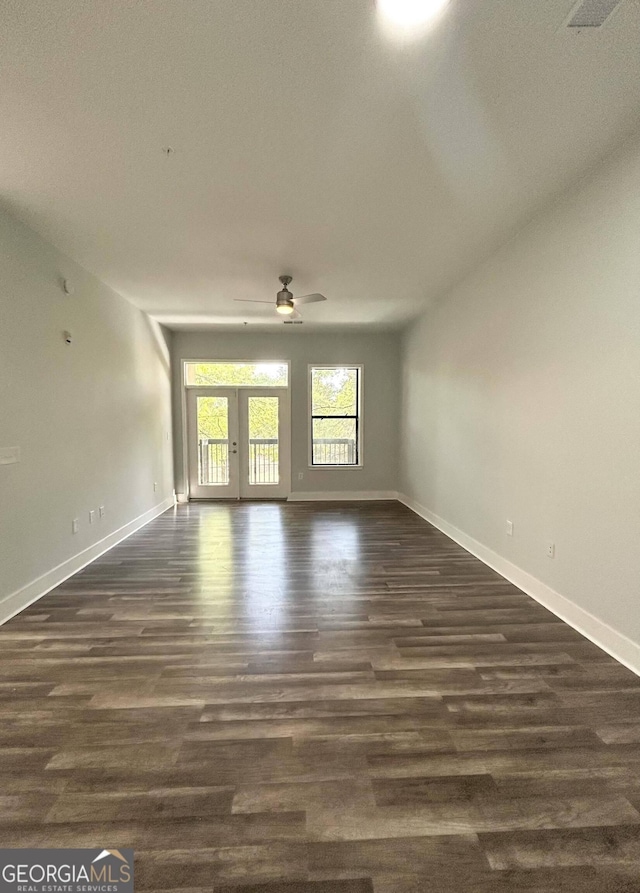 empty room with ceiling fan and dark wood-type flooring