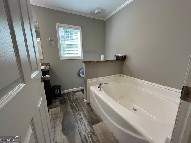 bathroom with vanity, ornamental molding, hardwood / wood-style floors, and a bath