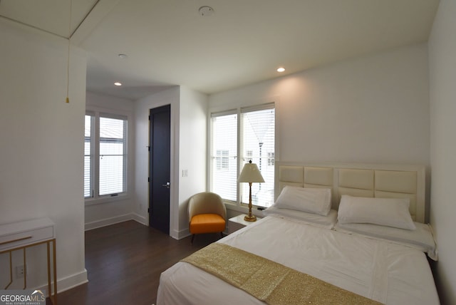 bedroom with multiple windows and dark hardwood / wood-style flooring