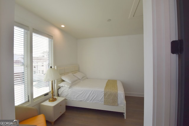 bedroom with multiple windows and dark hardwood / wood-style flooring