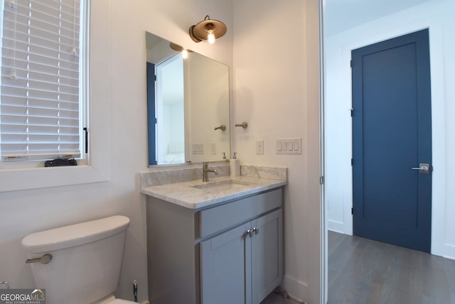 bathroom with vanity, hardwood / wood-style flooring, and toilet