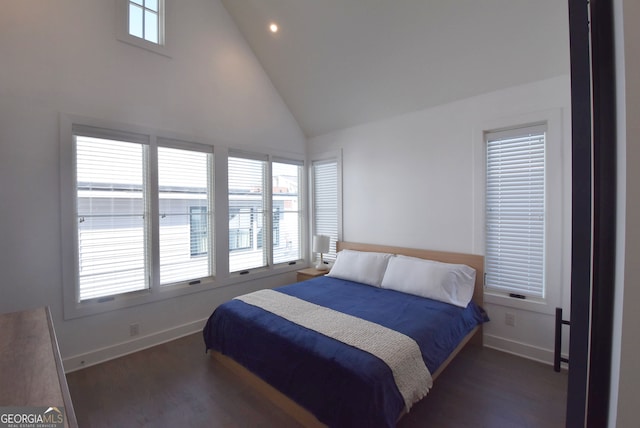 bedroom featuring dark hardwood / wood-style floors, multiple windows, and high vaulted ceiling