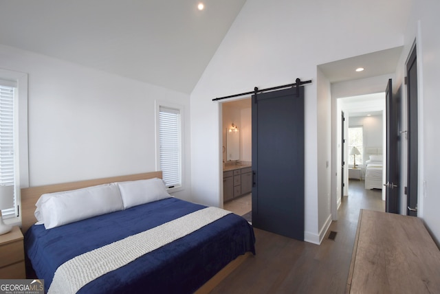 bedroom with a barn door, ensuite bathroom, high vaulted ceiling, and hardwood / wood-style flooring