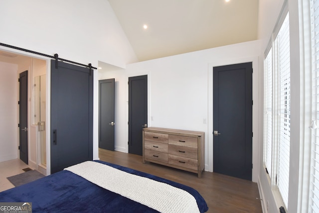 bedroom with a barn door, high vaulted ceiling, and dark wood-type flooring