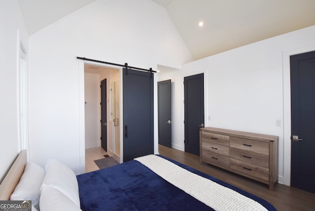 bedroom featuring a barn door, high vaulted ceiling, and dark hardwood / wood-style flooring