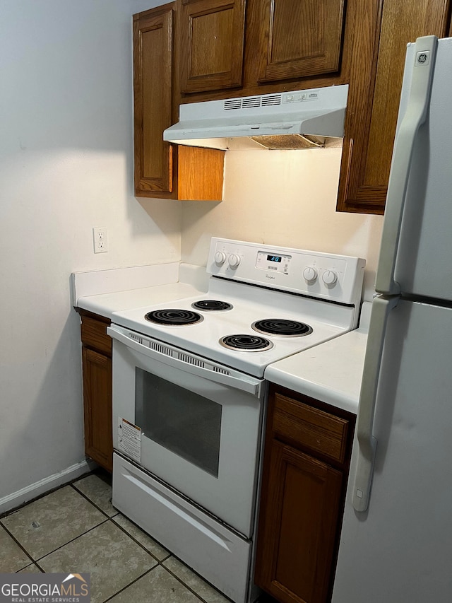 kitchen with light tile patterned floors and white appliances