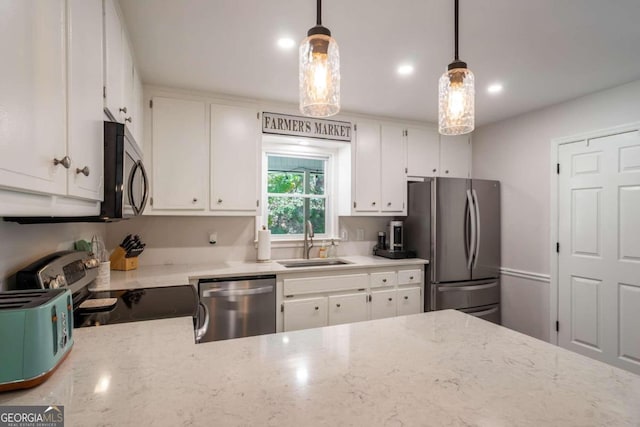 kitchen featuring appliances with stainless steel finishes, white cabinetry, sink, and pendant lighting