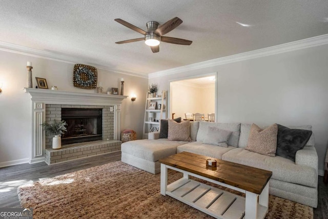 living room with a fireplace, a textured ceiling, ceiling fan, ornamental molding, and dark hardwood / wood-style floors