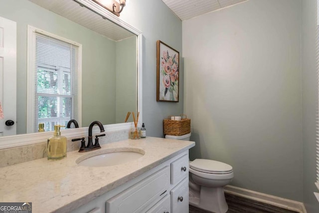 bathroom featuring vanity, hardwood / wood-style floors, and toilet