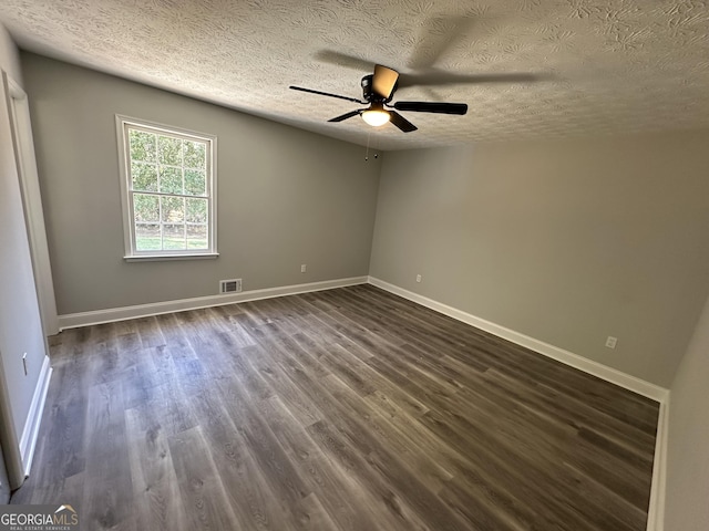 spare room with dark wood-type flooring, ceiling fan, and a textured ceiling