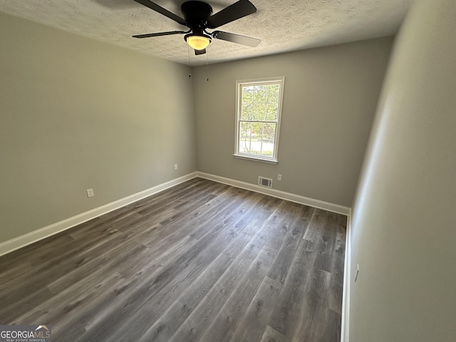 unfurnished room featuring dark hardwood / wood-style flooring, ceiling fan, and a textured ceiling