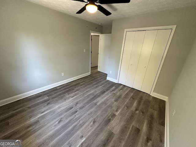 unfurnished bedroom with dark hardwood / wood-style flooring, a textured ceiling, a closet, and ceiling fan