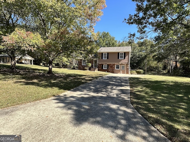 raised ranch featuring a garage and a front yard