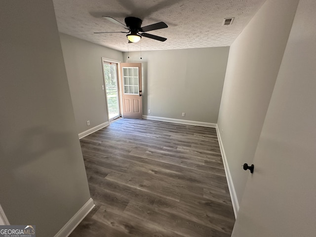 spare room featuring ceiling fan, dark hardwood / wood-style flooring, and a textured ceiling