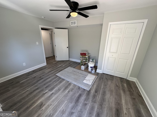 unfurnished bedroom featuring dark wood-type flooring, ceiling fan, and a closet