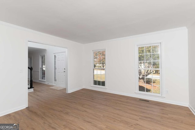 empty room featuring crown molding and wood-type flooring