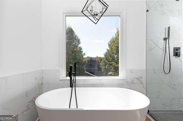 bathroom with tile walls and separate shower and tub