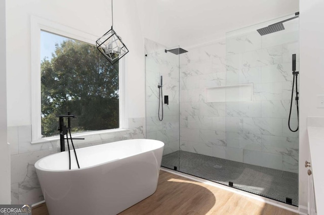 bathroom featuring tile walls, shower with separate bathtub, and hardwood / wood-style floors