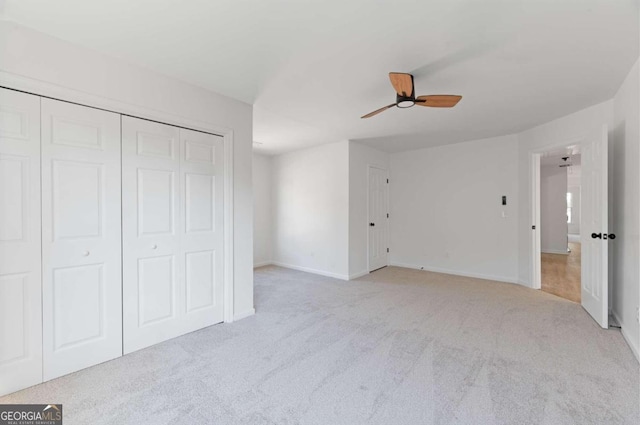 unfurnished bedroom with a closet, ceiling fan, and light carpet