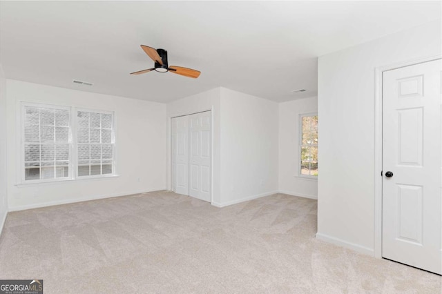 unfurnished bedroom with ceiling fan and light carpet