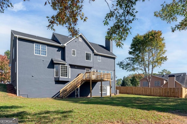 back of house featuring a wooden deck and a yard