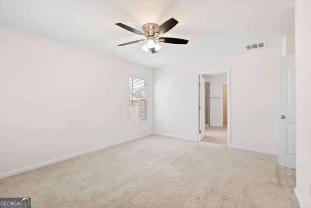 carpeted empty room featuring ceiling fan