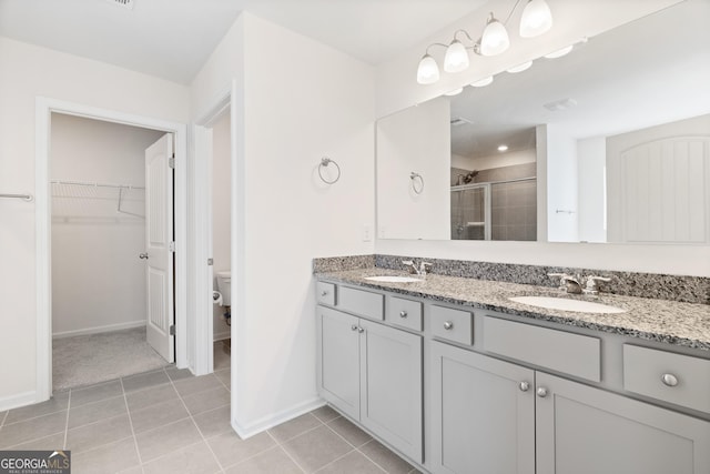 bathroom featuring vanity, an enclosed shower, tile patterned floors, and toilet