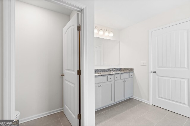 bathroom featuring vanity, toilet, and tile patterned flooring