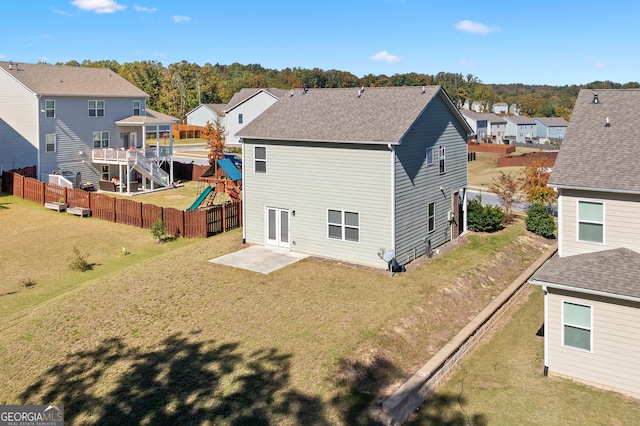 back of house with a lawn, a patio, and a playground