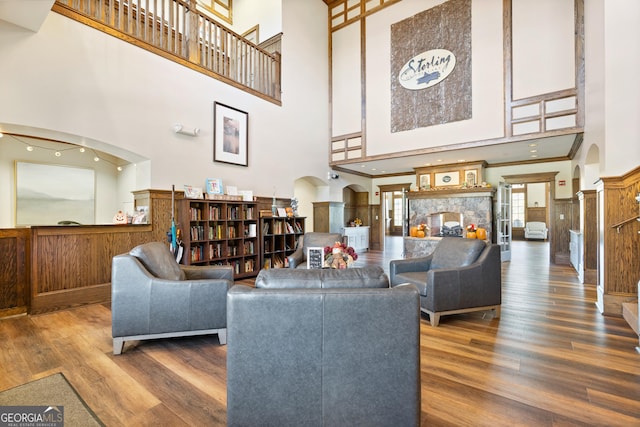 living room featuring ornamental molding, dark hardwood / wood-style flooring, and a high ceiling