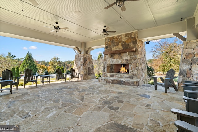 view of patio / terrace with an outdoor stone fireplace and ceiling fan