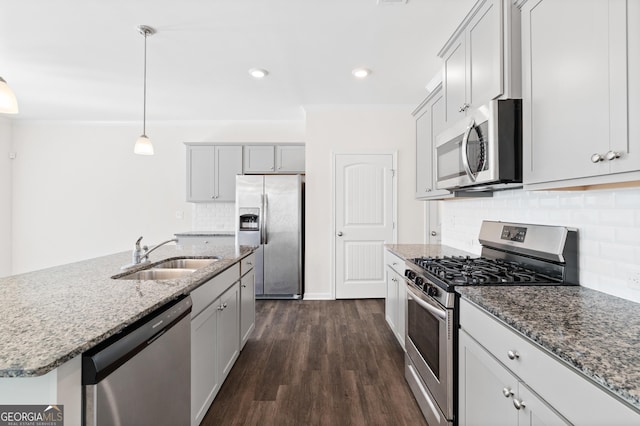 kitchen featuring dark hardwood / wood-style floors, pendant lighting, an island with sink, sink, and stainless steel appliances