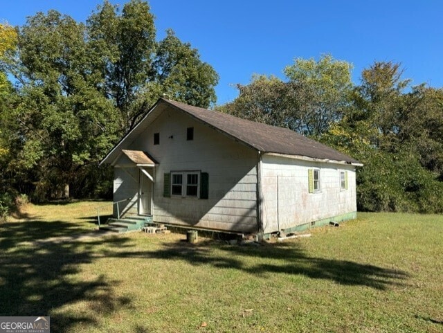 rear view of property featuring a lawn