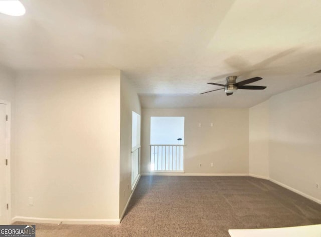 spare room featuring ceiling fan and dark colored carpet