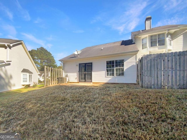 rear view of house featuring a lawn