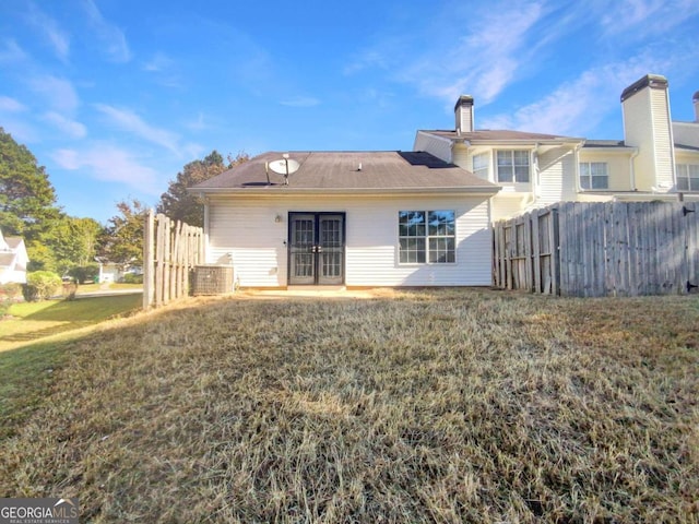 back of house featuring a yard and french doors