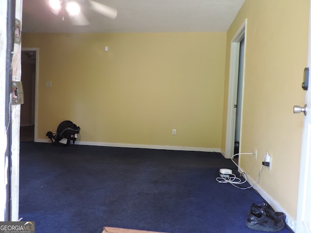 unfurnished room with dark colored carpet and ceiling fan