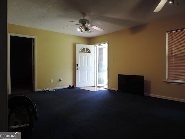 carpeted foyer featuring ceiling fan and a textured ceiling